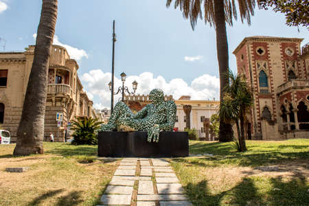 Statue of Rabarama near sea in Reggio Calabria, Italy. Old town of Reggio Calabria during a summer day. It is possible to see villa genoese Zerbi in the backgroundのeditorial素材