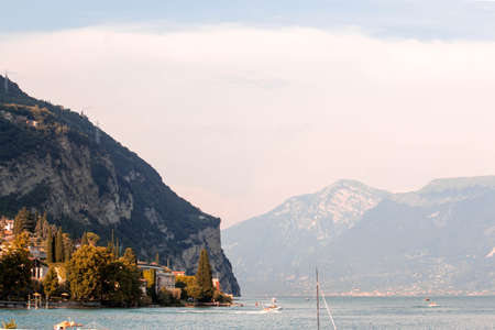 Lago di Garda ( Garda lake ) at sunset with light pink - a mountain in background. Long exposure time - little wavesの写真素材