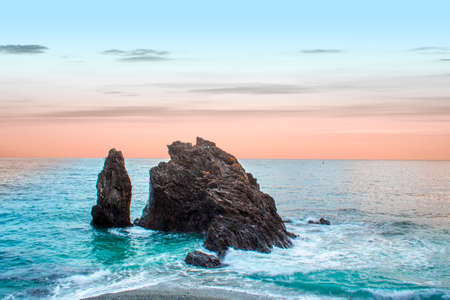 Inspirational sunset sky over the calm mediterranean sea and rock. Location: Monterosso al mare, cinque terre in Liguria region, Italy.の写真素材