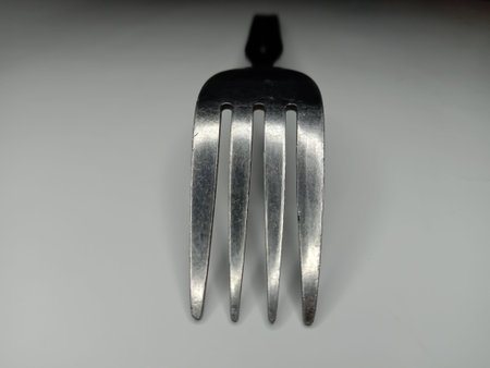 Close up of a metal fork on a white background. Selective focus.
