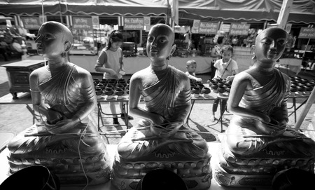 Children donate some money after praying to Buddha image のeditorial素材