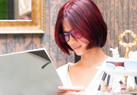 Nerdy Japanese girl is reading a blank book coverの写真素材
