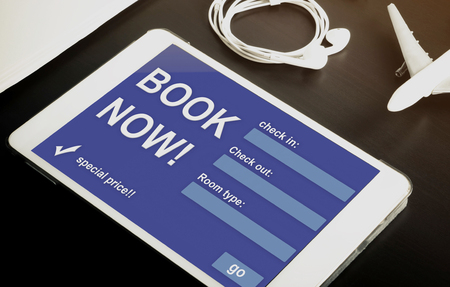 Book your hotel online using your Tablet or mobile devices now. Travel agency website on tablet. Online accommodation booking website on tablet screen.の写真素材