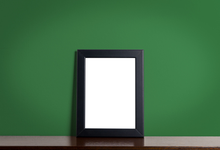 Black modern picture frame on green background. Black photo frame made of paper on a green cement texture.の写真素材