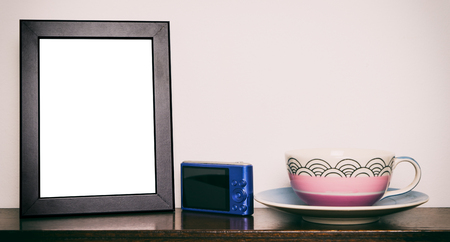 Photo frame with camera and pastel tea cupの写真素材