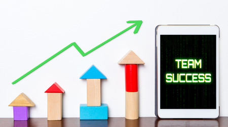 Team work success growing concept on tablet. Toy block rise with Team success diagram graph. Tablet with hi tech tech text Business team success rising up.の写真素材