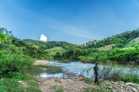 Phayao, Thailand - October 21, 2015: A farmer is walking on the Bank of Yom river on the mountain of Northern Thailand.のeditorial素材