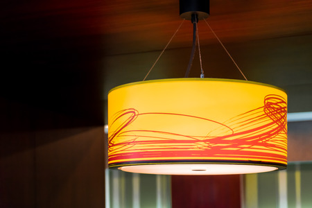 Orange ceiling lamp in dark room.の写真素材