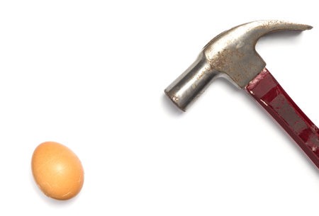 Hammer and egg isolated on white