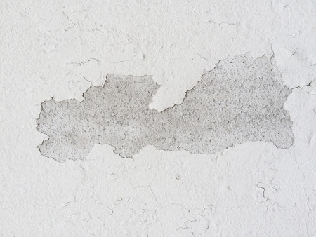 wear off paint on cracked white concrete cement wall texture.の写真素材