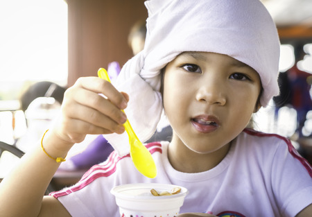 Thai Kindergarten Student licking ice creamの写真素材