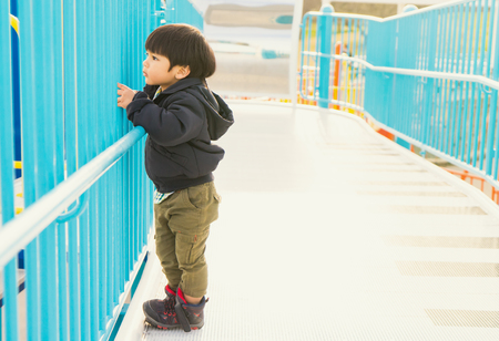 Japanese Boy standing near the fenceの写真素材