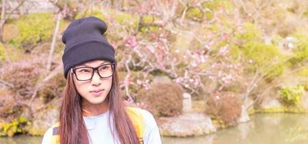 Japanese girl with glasses in a Plum blossom gardenの写真素材