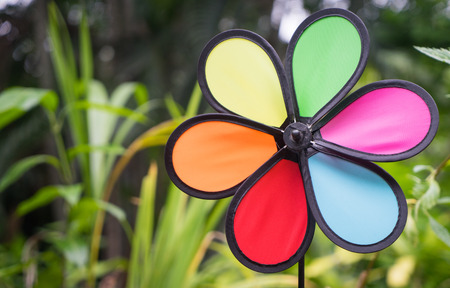 Colorful Toy wind turbine in green garden backgroundの写真素材