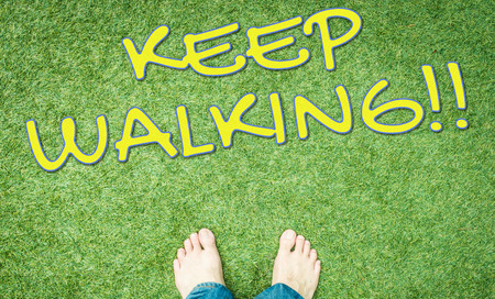 Bare feet on green grass keep walkingの写真素材