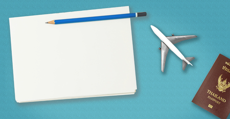 Blank travel notebook on blue background with plane and passport.の写真素材