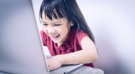 Asian kid is enjoy addiction of Computer and Internet. Japanese girl is playing game unconsciously...