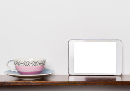 Pastel Tea cup with Blank white tablet screen.の写真素材