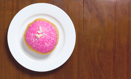 Strawberry Donut on white plate with wooden copy spaceの写真素材