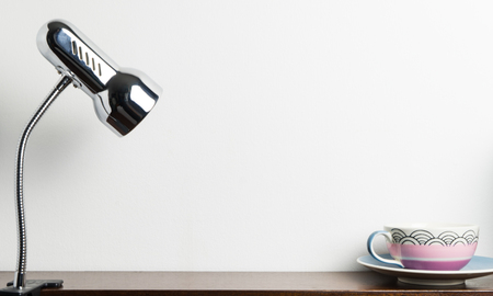 Metal Desk lamp with cup of tea and copy space in the middleの写真素材