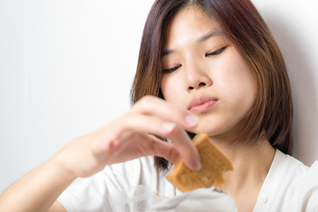 Asian girl having good time eating cake and getting fat.の写真素材