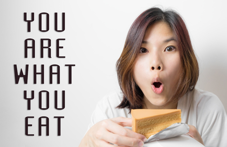 You are what you eat concept with a girl eating Chocolate cake.の写真素材