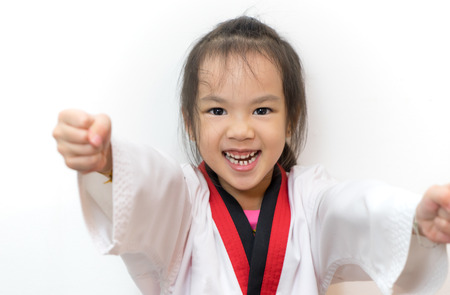 Asian girl is practicing Taekwondo on white backgroundの写真素材