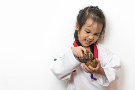 Asian girl Taekwondo breaking fruit on white background.の写真素材