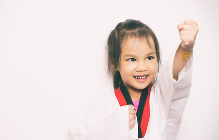 Asian girl is practicing Taekwondo on white backgroundの写真素材