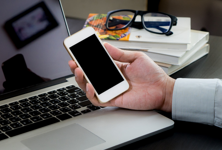 Business man holding phone with blank screen.の写真素材