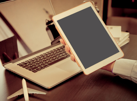 Business man hand holding a white tablet with blank screen for business travelの写真素材