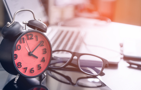 Office work desk with clock showing 4pm to finish workの写真素材