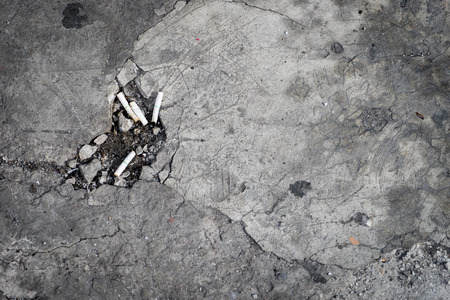 Cement Floor with a hole full of Cigarette buttsの写真素材