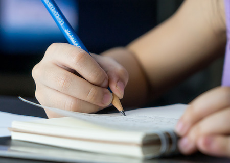 Kid is practicing writing with pencil and notebookの写真素材