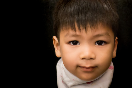 Liitle asian boy is smiling in low key toneの写真素材