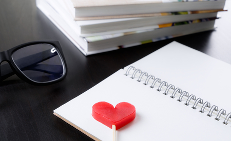 Red heart on blank book in library tableの写真素材