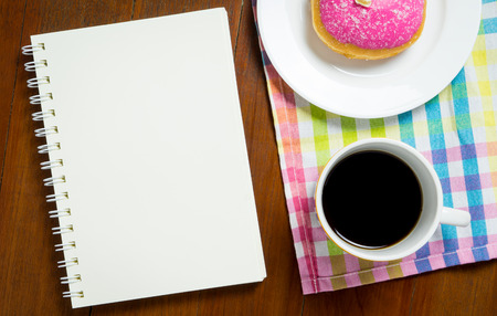 Blank book on cafe table with coffee and donutの写真素材
