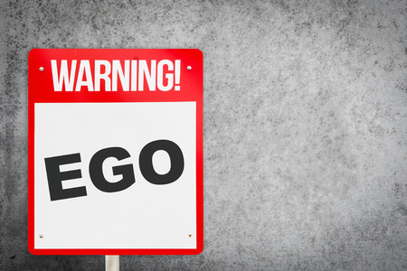 Red Warning EGO signage on cement copy spaceの写真素材
