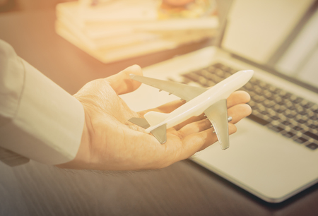 Business man holding a toy plane for travel conceptの写真素材