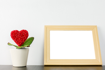 Heart flower in wihite pot with wooden photo frameの写真素材