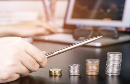 Business man pointing pen up as profit on Stock Market is growing up