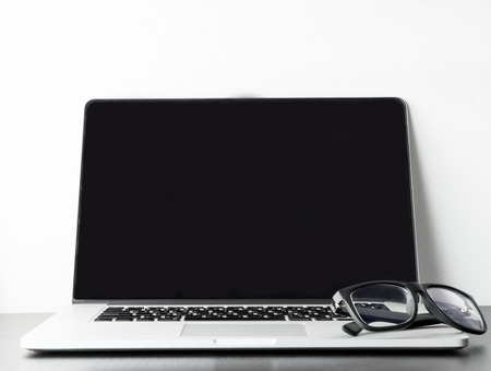 Blank Laptop notebook screen on white blackground with eye glassesの写真素材