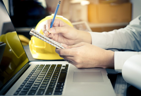 Construction engineer is taking note on a notebook
