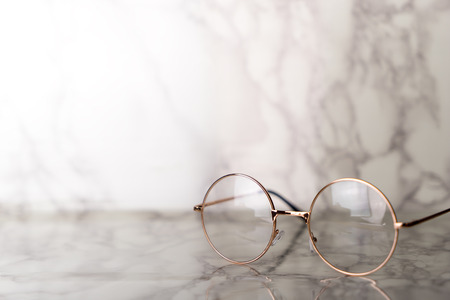 Vintage golden Eyeglasses on luxury marble stone tableの写真素材