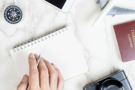 Travel blogger is writing travel review on notebook with accessoriesの写真素材