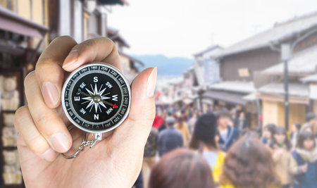 Explorer holding compass to travel in Japan blurred backgroundの写真素材