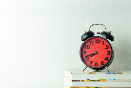 Alarm clock with morning coffee on office tableの写真素材