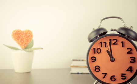 Alarm clock with love concept flower on the backgorundの写真素材