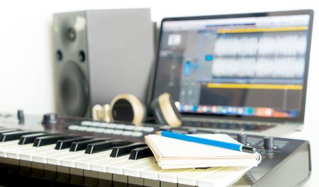Notebook and Music Keyboard on Music studio working desktop for song writerの写真素材