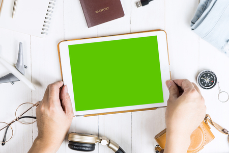 Traveler is picking tablet with blank screen for mobile application mock upの写真素材